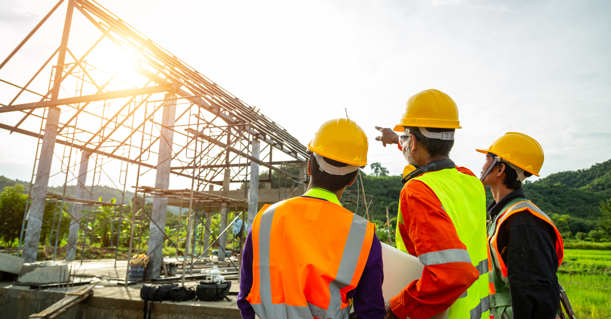 Construction workers looking at a building